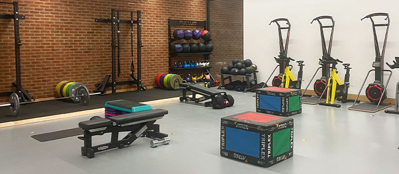Studio 2 set up with equipment for GGT - squat racks, ski ergs, bench, box