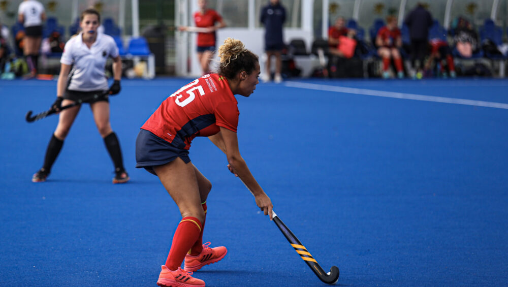 Girl playing hockey in UOB Sport & Fitness kit