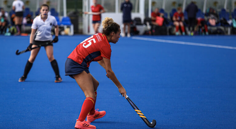 Girl playing hockey in UOB Sport & Fitness kit