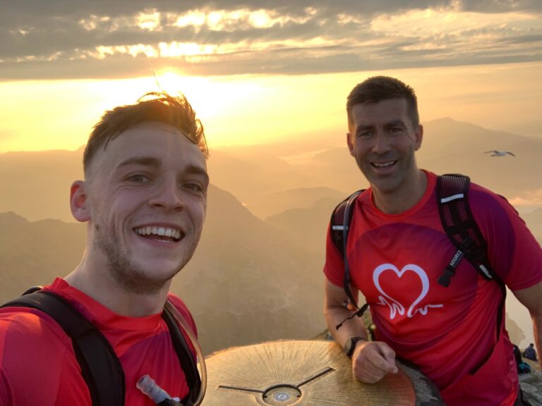 Selfie of Kacper and Ross at the top of a mountain with the sunset in the background