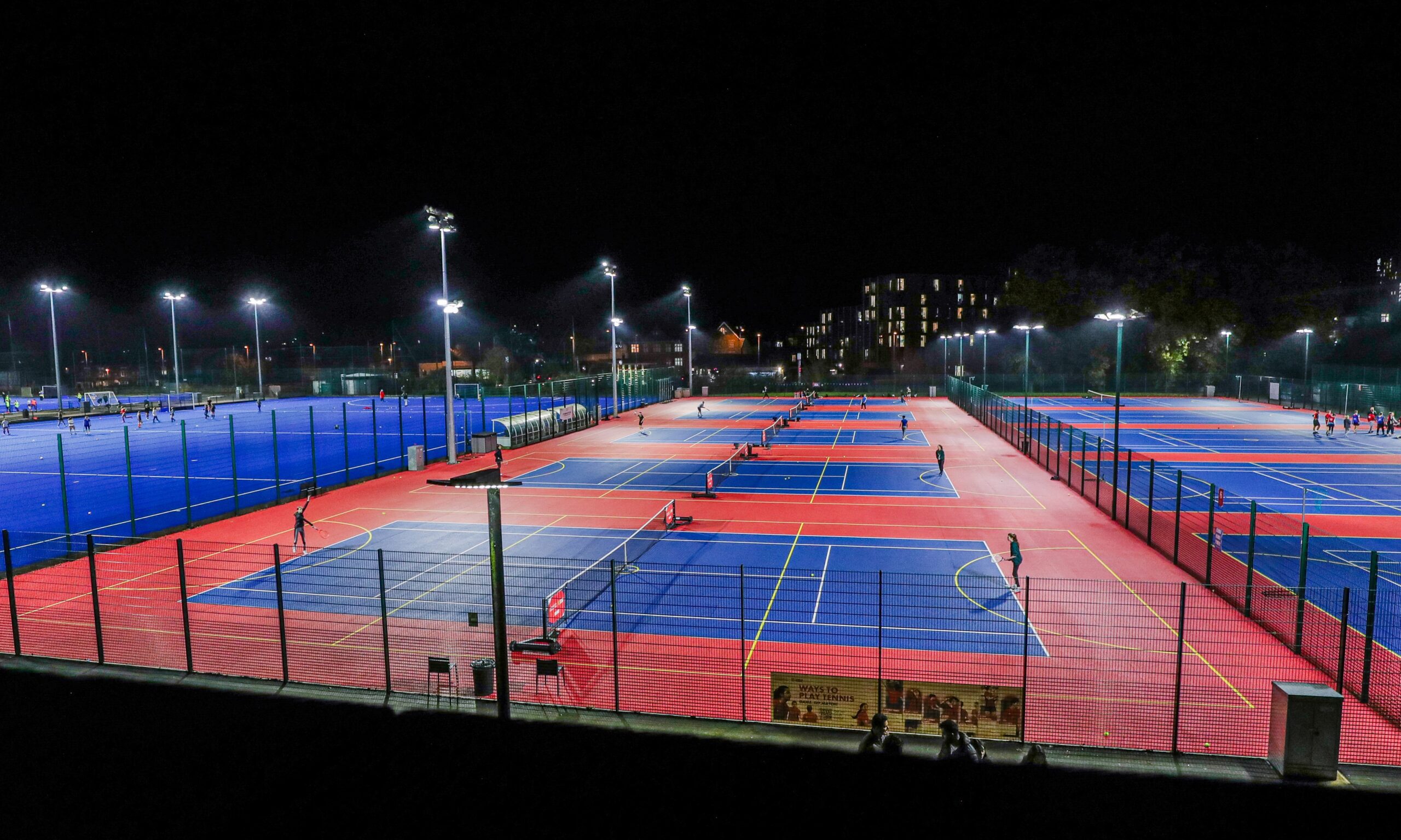 An overview image of the tennis courts at Sport & Fitness - colours of blue and red.