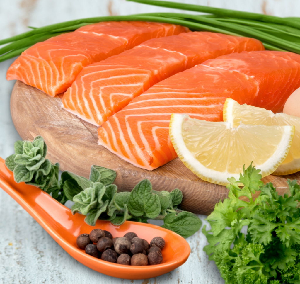 Salmon alongside vegetables and lemon slice