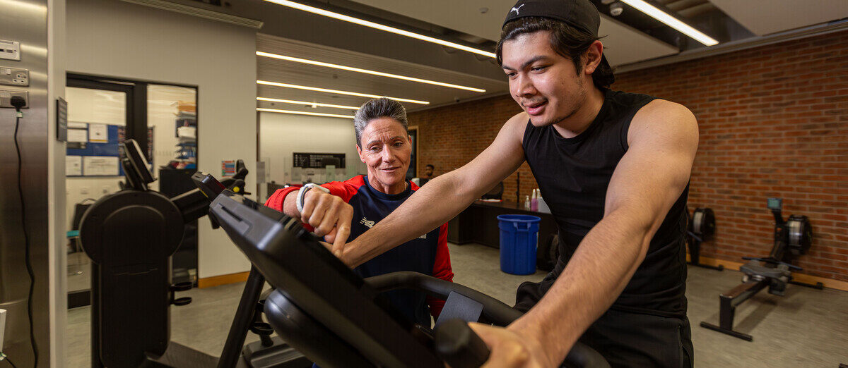 Janine, a gym instructor, supporting a member in Sport & Fitness gym.