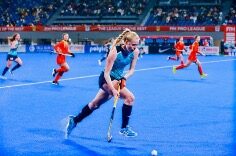 Lottie Bingham playing Hockey on pitch