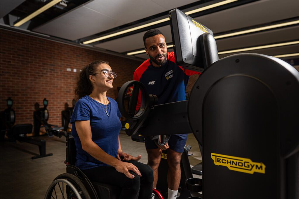 Gym instructor supporting a member of staff.