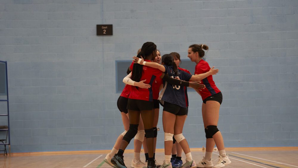 Women's volleyball team hugging